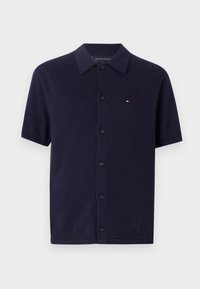 Short-sleeve navy blue polo shirt made of cotton, featuring a front button closure and a small embroidered logo on the left chest.
