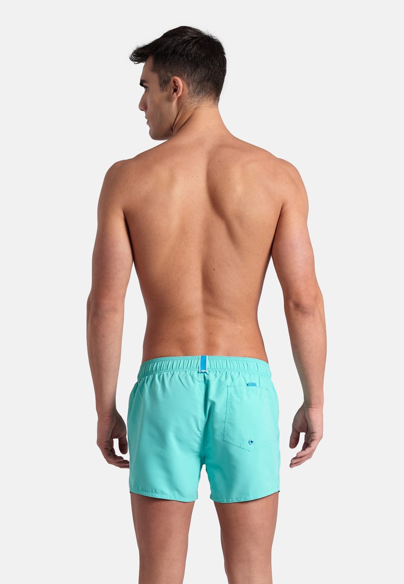 Męskie szorty kąpielowe w jasnym odcieniu turkusu. Posiadają elastyczny pas i jedną tylną kieszeń z zapięciem na guzik. Miękki materiał.