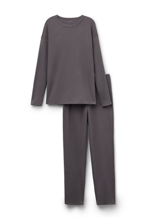 Top de manga larga gris con canalé y corte relajado, combinado con pantalones de canalé a juego que presentan un diseño de pierna recta.