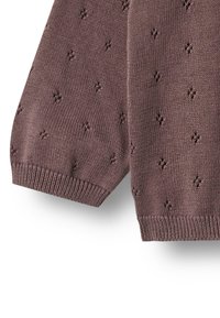 Strikket brunt stof med små hulmønstre og ribstrikkede manchetter, der viser nærbillede af ærmekant og nederst på stoffet.