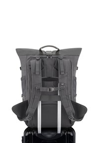 Gray fabric backpack with padded shoulder straps, top handle, and mesh back support, designed to attach to a wheeled suitcase.