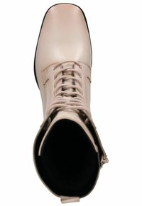 Botín de tobillo con cordones en suave piel beige, con punta redonda, superficie lisa, suela negra y detalle de cremallera en el lateral para facilitar su uso.