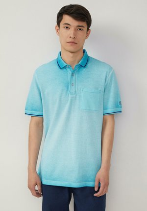 Helles blaues Polohemd mit texturiertem Finish, kontrastierenden dunkelblauen Kragen und Saumkanten, Drei-Knopf-Leiste und einer Brusttasche.
