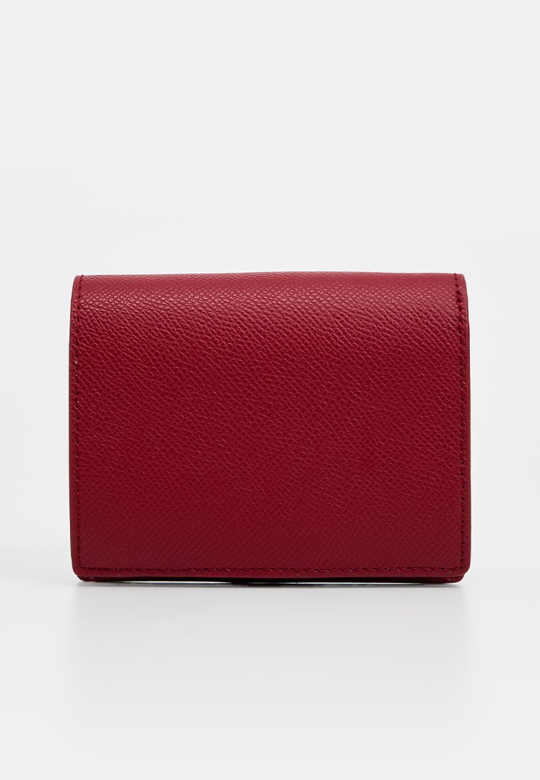 Billetera de cuero rojo con una superficie texturizada, forma rectangular compacta y bordes cosidos. Presenta un diseño de pliegue sin hardware visible.