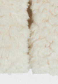 Pelliccia artificiale color crema con una texture morbida e soffice. Il materiale appare spesso, vellutato e tagliato in modo uniforme, con leggere variazioni di tonalità.