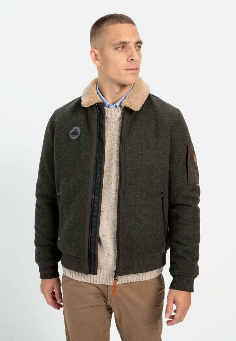 Green wool-blend bomber jacket with a beige faux fur collar, zip closure, ribbed cuffs, and a badge on the left sleeve.