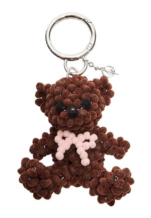 Portachiavi a forma di orsetto marrone realizzato in pompon testurizzati, con occhi in plastica nera e un fiocco rosa chiaro. Anello in metallo per il fissaggio.