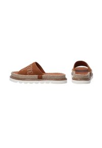 Brune ruskinds slip-on sandaler med et design af jute reb, hvid ydersål og præget tekst på overdelen. Åben hæl og rund tå.