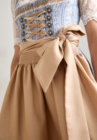 Blauer und weißer gemusterter Dirndl mit Spitzenärmeln, einer geschnürten Brustpartie, dekorativen Beschlägen und einem beigen Rock mit einer Schleife.