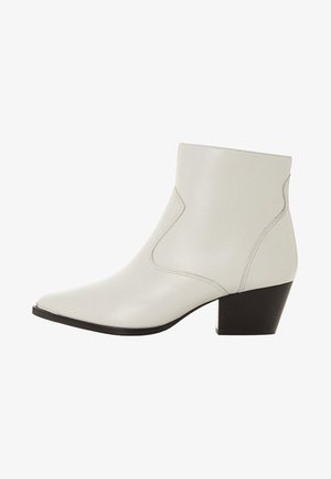 Białe skórzane botki za kostkę z ostrym noskiem i niskim, warstwowym obcasem. Szczegóły szwów wzdłuż boków dodają subtelnych elementów designu.