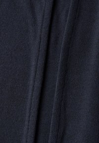 Mörk marinblå stickad tyg med en slät struktur, med vertikala ribbor och en tvåpaneldesign med rak kantfinish.