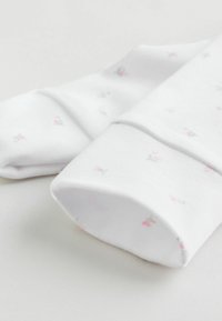 Hvide bomuldssokker med små rosa og grå blomsterprint, med en glat tekstur og design med foldet kant.