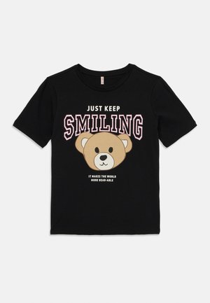 T-shirt preta de manga curta com uma cara de urso em cartoon e o texto "APENAS CONTINUE A SORRIR", com detalhes em rosa e branco.