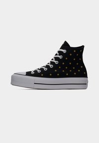 Μαύρο ψηλό αθλητικό παπούτσι με λευκή σόλα και κορδόνια, διακοσμημένο με ένα σχέδιο μικρών κίτρινων αστεριών στο πλάι.