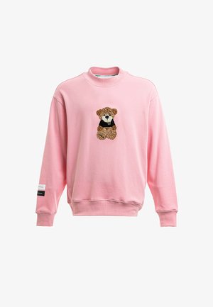 Sudadera rosa de manga larga con un oso de peluche con un suéter negro bordado en el centro delantero y una pequeña etiqueta en la manga izquierda.