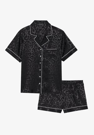 Black leopard print pajama set featuring a short-sleeve button-up shirt with white piping and matching shorts with an elastic waistband.