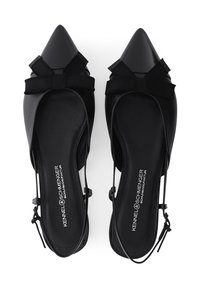 Zwarte puntige platte schoenen gemaakt van glad leer, met een strikdetail en verstelbare bandjes. De zool is plat met een lichte glansafwerking.