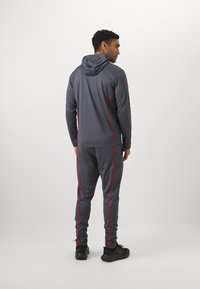 Under Armour TRACKSUIT - Tracksuit - castlerock/racer red