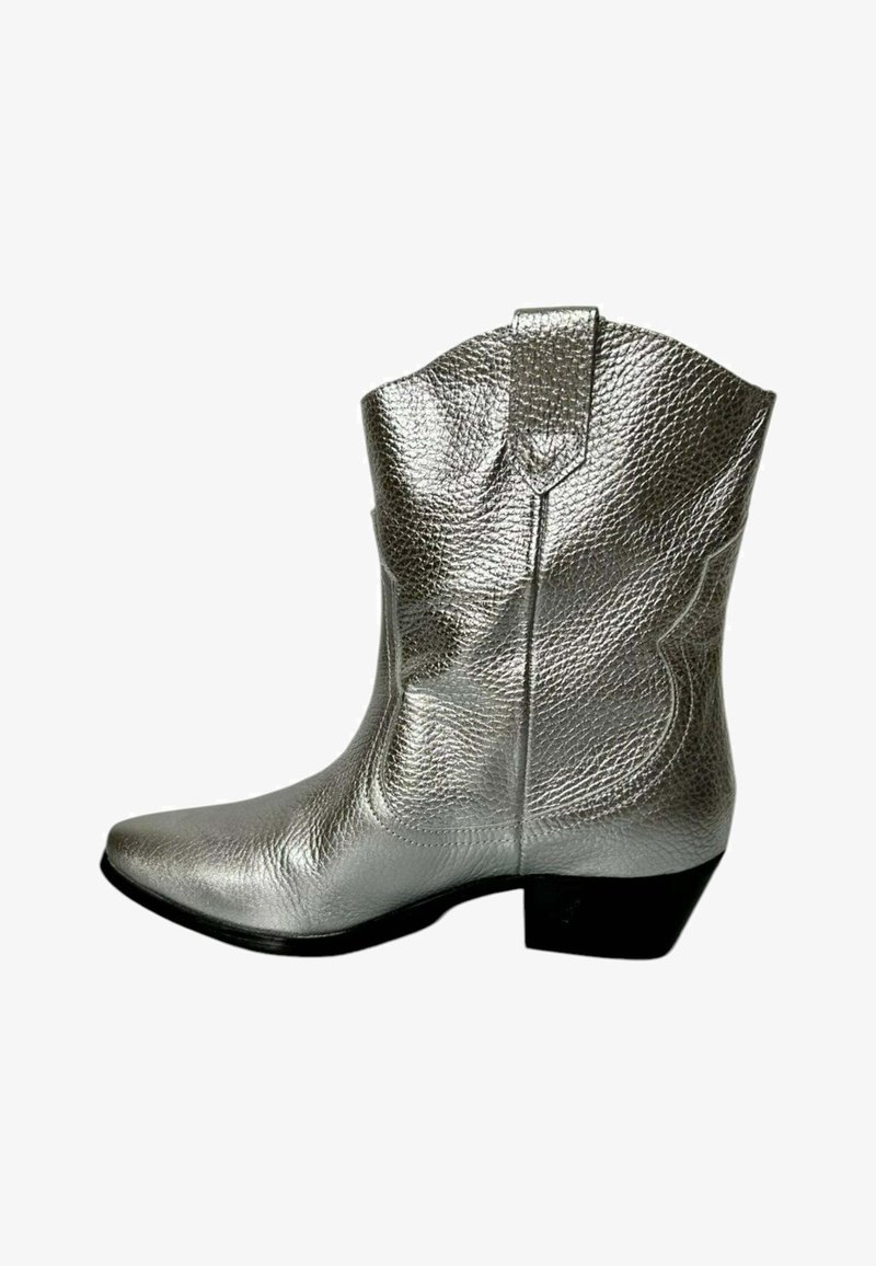 Bota vaquera plateada con un acabado de cuero texturizado, punta afilada, costuras decorativas y un tacón bajo. Cuenta con una lengüeta en el tobillo.