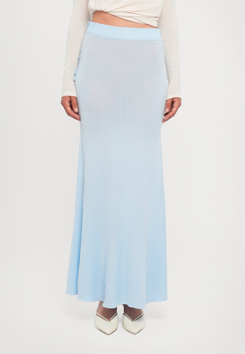 Saia longa azul clara, feita de tecido macio, com uma cintura ajustada e discretos bolsos laterais. Textura suave com um silhueta esvoaçante.