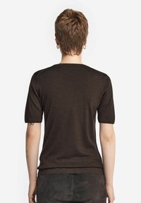 Brun kortærmet strikket top med rund hals, der har en glat tekstur og ribbede manchetter, set fra ryggen på en neutral baggrund.