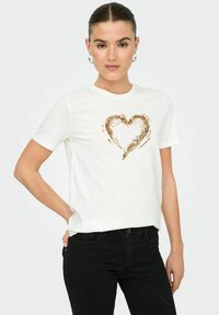 Camiseta de algodón blanca con un diseño de corazón dorado brillante en el frente, con un cuello redondo clásico y mangas cortas.
