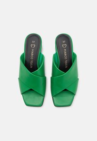Sandales en plastique vertes avec des brides croisées, bouts carrés et talons blocs bas. L'intérieur présente une marquage doré. Taille 37 indiquée.