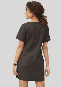 Zwart kortere mouw jurk van textuurstof, getailleerd ontwerp, ronde halslijn en onzichtbare ritssluiting aan de achterkant.