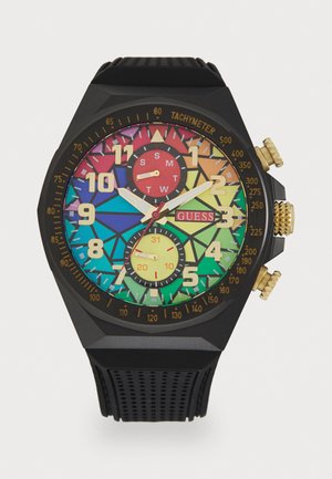 Svart gummiklocka med oktagonal boett, färggerad geometrisk urtavla, gyllene detaljer, tachymeterskalor och dubbla små urtavlor i röd och gul.