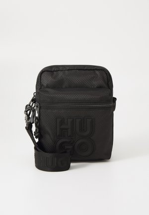 Borsa rettangolare nera realizzata in tessuto testurizzato, con un evidente logo "HUGO", chiusura con zip e tracolla regolabile.