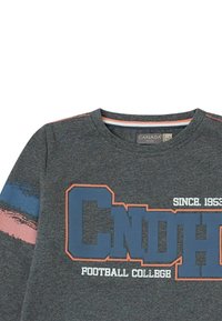 Sudadera gris de algodón con cuello redondo, que presenta el texto "CNDH FOOTBALL COLLEGE" en azul, y rayas rosas y azules en las mangas.