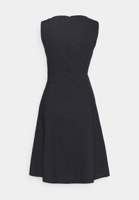 Černé šaty bez rukávů s obepnutým korzetem a rozšiřující sukní. Hladká tkanina s diskrétním zipem na zadní straně, která poskytuje elegantní siluetu.