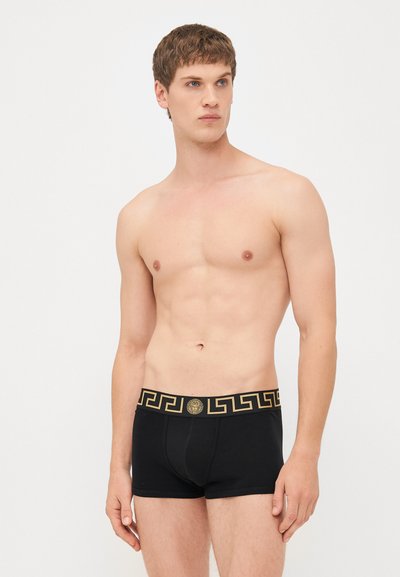 Boxeri negri dintr-un amestec de bumbac, cu un model de cheie grecească aurie pe elastic, accentuat de un logo central.