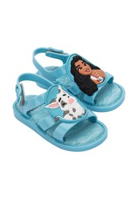 Sandales pour enfants bleues en matériau flexible, avec des personnages moulés : une fille aux cheveux bruns et une vache, dotées d'une semelle intérieure à motifs.