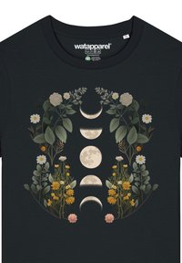 Schwarzes T-Shirt mit einem floralen Design in der Mitte, das Monde zeigt. Die Blumen umfassen Gänseblümchen und gelbe Blüten, umgeben von grünen Blättern.