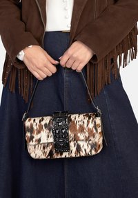 Borsa in stampa animalier marrone e crema con chiusura gioiello nera. Forma strutturata, di piccole dimensioni, dotata di tracolla staccabile per diverse opzioni di trasporto.