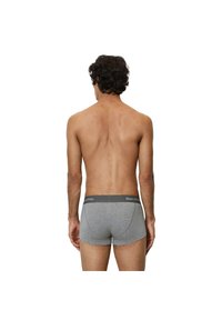 Boxers en coton gris avec une taille noire portant le nom de la marque. Le design est ajusté avec une texture lisse.