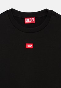 Μαύρο φούτερ με ριμπ λαιμόκοψη, με ένα μικρό κόκκινο τετράγωνο λογότυπο που φέρει το λευκό γράμμα 'D' και το όνομα της μάρκας "DIESEL" σε έντονο κόκκινο.