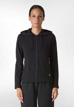 Sudadera negra con cremallera y capucha, que cuenta con mangas largas y un pequeño logo en la parte inferior derecha. Fabricada con una tela suave y texturizada.