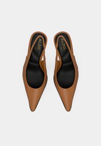 Escarpins à talons avec lanière arrière marron, à bout pointu, en cuir lisse, dotés d'une semelle intérieure noire et d'accents de design minimalistes.