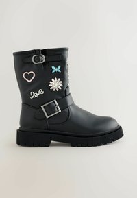 Botine negre din piele cu talpă texturată, având aplicații decorative inclusiv un fluture, o inimă, o floare și cuvântul "dragoste".