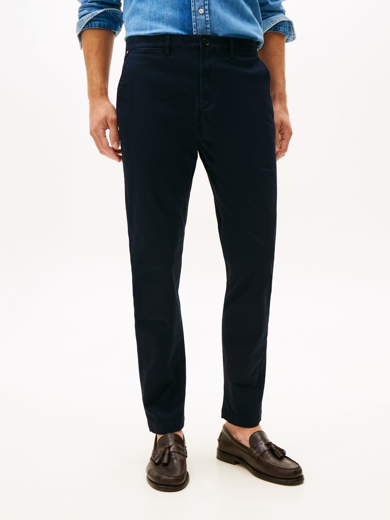 Chinos blu navy in cotone con vestibilità slim, dotati di tasche laterali e passanti per cintura, abbinati a mocassini marroni.