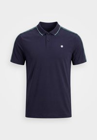 Μπλούζα πόλο σε ναυτικό μπλε χρώμα με κοντά μανίκια και δύο κουμπιά στην πατιλέτα, πράσινες και λευκές ρίγες στους ώμους και το γιακά, καθώς και μικρό λευκό λογότυπο στο στήθος.