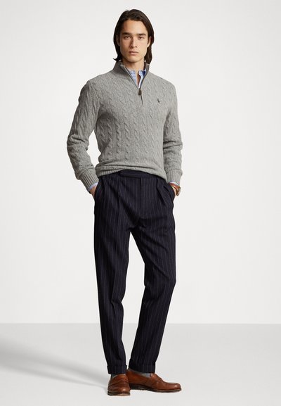 Gray knitted sweater with a zippered collar, paired with navy pinstriped trousers and brown leather shoes. Subtle textured patterns visible.