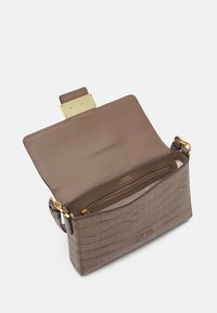 Brązowa torebka skórzana z tłoczeniem w kształcie krokodyla, z zapięciem w kolorze złotym. Wnętrze jest przestronne i zawiera kieszeń na zamek.