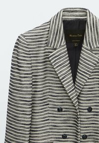 Randig svart och vit dubbelknäppt kavaj med breda slag och fyra svarta knappar, märkt Massimo Dutti, tillverkad i Portugal.