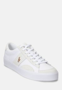 Vit lågtoppad sneaker med vita snörningar, detaljer i mocka och broderad polo-spelare-logotyp på sidan, visad från en lätt vinkel på en enfärgad bakgrund.