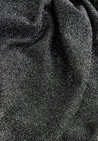 Zwarte stof met een gestructureerd oppervlak en kleine zilveren spikkeltjes, die een sprankelend effect creëren. Het materiaal lijkt zacht en valt soepel.