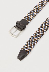 Cinturón trenzado con hebras tejidas en azul, marrón, blanco y negro, punta y hebilla de cuero oscuro, exhibido sobre una superficie clara.