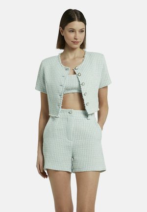 Hellblau strukturierter Stoff in einem zweiteiligen Set, bestehend aus einer kurzärmeligen, taillierten Jacke mit Knöpfen und hoch taillierten Shorts mit Taschen.